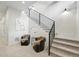 Modern staircase with carpeted steps, a black railing, two comfortable chairs and a modern piece of art at 380 S Humboldt St, Denver, CO 80209