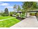 Beautifully landscaped front yard of a home with a covered carport and lush green lawn at 6526 S Elmwood St, Littleton, CO 80120