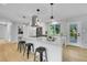 Modern kitchen with a large island, stainless steel appliances, and sleek pendant lighting at 6526 S Elmwood St, Littleton, CO 80120