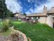 Well-maintained backyard with lush green grass, a brick-lined flowerbed, and a spacious deck at 540 S Forest St # A2, Denver, CO 80246