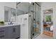 Contemporary bathroom with glass enclosed shower, gray vanity, and doorway to the bedroom at 1735 Crestone Dr, Longmont, CO 80504