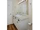 Bright bathroom featuring a white vanity with ample storage and natural wood flooring at 1735 Crestone Dr, Longmont, CO 80504