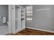 Bedroom closet features custom shelving, rods, hardwood flooring and a neutral color palette at 1735 Crestone Dr, Longmont, CO 80504
