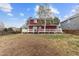 Backyard view featuring a spacious yard, wooden deck, and red house siding at 6202 Ralston St, Frederick, CO 80530