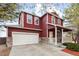 Charming two-story red home with a two-car garage, stone accents, and a welcoming front porch at 6202 Ralston St, Frederick, CO 80530