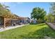 Spacious backyard featuring a patio with pergola, lush lawn, and a storage shed at 7790 Kendall St, Arvada, CO 80003