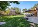 Expansive backyard showcasing a manicured lawn, stone planters, patio seating, and a charming pergola at 7790 Kendall St, Arvada, CO 80003