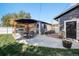 Spacious backyard featuring patio dining and lounging areas, a well-manicured lawn, and a modern shed at 7790 Kendall St, Arvada, CO 80003