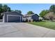 A home exterior showcasing driveway leading to a detached garage and landscaped lawn at 7790 Kendall St, Arvada, CO 80003