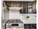 A close-up of a modern range and white subway tile backsplash are highlights in the kitchen at 7790 Kendall St, Arvada, CO 80003