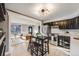 Modern kitchen with stainless steel appliances, hardwood floors, pendant lighting and seamless view of the living room at 7790 Kendall St, Arvada, CO 80003