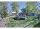 Inviting backyard with a trampoline, garden area, storage shed, and mature trees at 8745 W Ottawa Ave, Littleton, CO 80128
