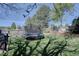 Beautiful backyard with a trampoline, garden, and mature trees, perfect for outdoor enjoyment at 8745 W Ottawa Ave, Littleton, CO 80128