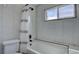 Bathroom featuring a bathtub with shower, white tiling, and a window for natural light at 8745 W Ottawa Ave, Littleton, CO 80128