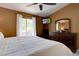Bright bedroom featuring a TV, a window, and an ornate dresser with mirror at 8745 W Ottawa Ave, Littleton, CO 80128