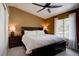 Comfortable bedroom with a ceiling fan, a large window, and bedside tables with lamps at 8745 W Ottawa Ave, Littleton, CO 80128