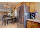 Well-lit kitchen featuring stainless steel appliances, wooden cabinets, and an adjacent dining area at 8745 W Ottawa Ave, Littleton, CO 80128