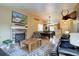 Spacious living room with a charming brick fireplace, open to the dining area and kitchen at 8745 W Ottawa Ave, Littleton, CO 80128