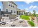 Beautiful backyard with a hot tub, manicured lawn, and white rocking chairs on a stone patio at 6912 Sunstrand Ct, Castle Pines, CO 80108