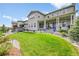 Expansive backyard featuring a well-maintained lawn, patio, and lush landscaping at 6912 Sunstrand Ct, Castle Pines, CO 80108