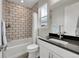Bathroom featuring gray subway tile in shower-tub combo and vanity with black countertop at 6912 Sunstrand Ct, Castle Pines, CO 80108