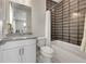 Bright bathroom with a gray accent wall, subway tiled shower, and white cabinets at 6912 Sunstrand Ct, Castle Pines, CO 80108