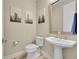 Stylish powder bathroom with pedestal sink, elegant mirror and attractive artwork at 6912 Sunstrand Ct, Castle Pines, CO 80108
