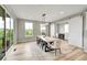 Bright dining room features a modern chandelier, an outdoor view, and sliding barn door to office at 6912 Sunstrand Ct, Castle Pines, CO 80108