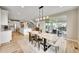 Bright dining room and open floor plan with modern light fixture and sliding glass door to patio at 6912 Sunstrand Ct, Castle Pines, CO 80108