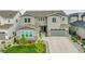 Aerial view of a two-story home with a landscaped yard and a long driveway, featuring a mix of stone and siding at 6912 Sunstrand Ct, Castle Pines, CO 80108
