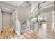 Bright and spacious foyer featuring hardwood floors, a staircase with white railings, and natural light streaming through windows at 6912 Sunstrand Ct, Castle Pines, CO 80108