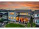 Rear view of the home at sunset, showing the patio, hot tub, lawn, and well-lit windows at 6912 Sunstrand Ct, Castle Pines, CO 80108