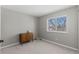 This bedroom features neutral walls, a window overlooking the outdoors and a small storage cabinet at 6393 Laguna Cir, Highlands Ranch, CO 80130
