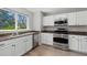 Bright kitchen with stainless steel appliances, granite counters, and ample white cabinets at 6393 Laguna Cir, Highlands Ranch, CO 80130