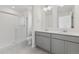 Bathroom featuring double sinks, a glass-doored shower, and tile floors at 18708 E 99Th Ave, Commerce City, CO 80022
