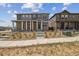 Beautiful two-story home with stone accents, covered porch, landscaped front yard, and sidewalk at 18708 E 99Th Ave, Commerce City, CO 80022