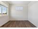 Sunny bedroom with a large picture window and sleek, dark wood-look flooring at 1923 Westport Ave, Berthoud, CO 80513