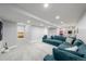 Large basement featuring gray plush carpet, wet bar, a comfy blue sectional, and open access to a bedroom at 2153 Mountain Iris Dr, Erie, CO 80516