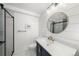 Modern bathroom showcasing shiplap walls, a stylish vanity, and a sleek glass-enclosed shower with contrasting tile at 2153 Mountain Iris Dr, Erie, CO 80516
