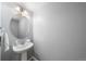 Powder bathroom with pedestal sink, round mirror and modern fixtures at 2153 Mountain Iris Dr, Erie, CO 80516