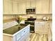 Kitchen boasts white cabinets, stainless steel appliances, and an island with black countertops at 2153 Mountain Iris Dr, Erie, CO 80516