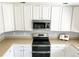 Well-lit kitchen with stainless steel appliances, white cabinets, and plenty of counter space at 2153 Mountain Iris Dr, Erie, CO 80516