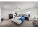 Bright main bedroom with ceiling fan, a bench at the foot of the bed, and natural light from the two windows at 2153 Mountain Iris Dr, Erie, CO 80516