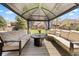 Inviting outdoor space featuring a covered lounge area with comfortable seating and a fire pit, perfect for relaxing and entertaining at 2153 Mountain Iris Dr, Erie, CO 80516