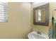 Bright half bathroom features tiled mirror and white pedestal sink at 2261 Alpine Dr, Erie, CO 80516