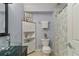 Stylish bathroom with a modern glass sink, corner cabinet, and a shower with floral-patterned curtain at 2261 Alpine Dr, Erie, CO 80516