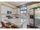 Bright, modern kitchen with white cabinets, stainless appliances, island with seating and granite countertop at 2261 Alpine Dr, Erie, CO 80516