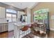 Bright, open kitchen features white cabinets, granite countertops, stainless appliances, island with seating, and adjacent dining area at 2261 Alpine Dr, Erie, CO 80516