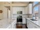 Bright kitchen with white cabinets, stainless steel appliances, and granite countertops at 2261 Alpine Dr, Erie, CO 80516