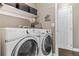The modern laundry room has sleek washer and dryer with a clean, bright design at 2261 Alpine Dr, Erie, CO 80516